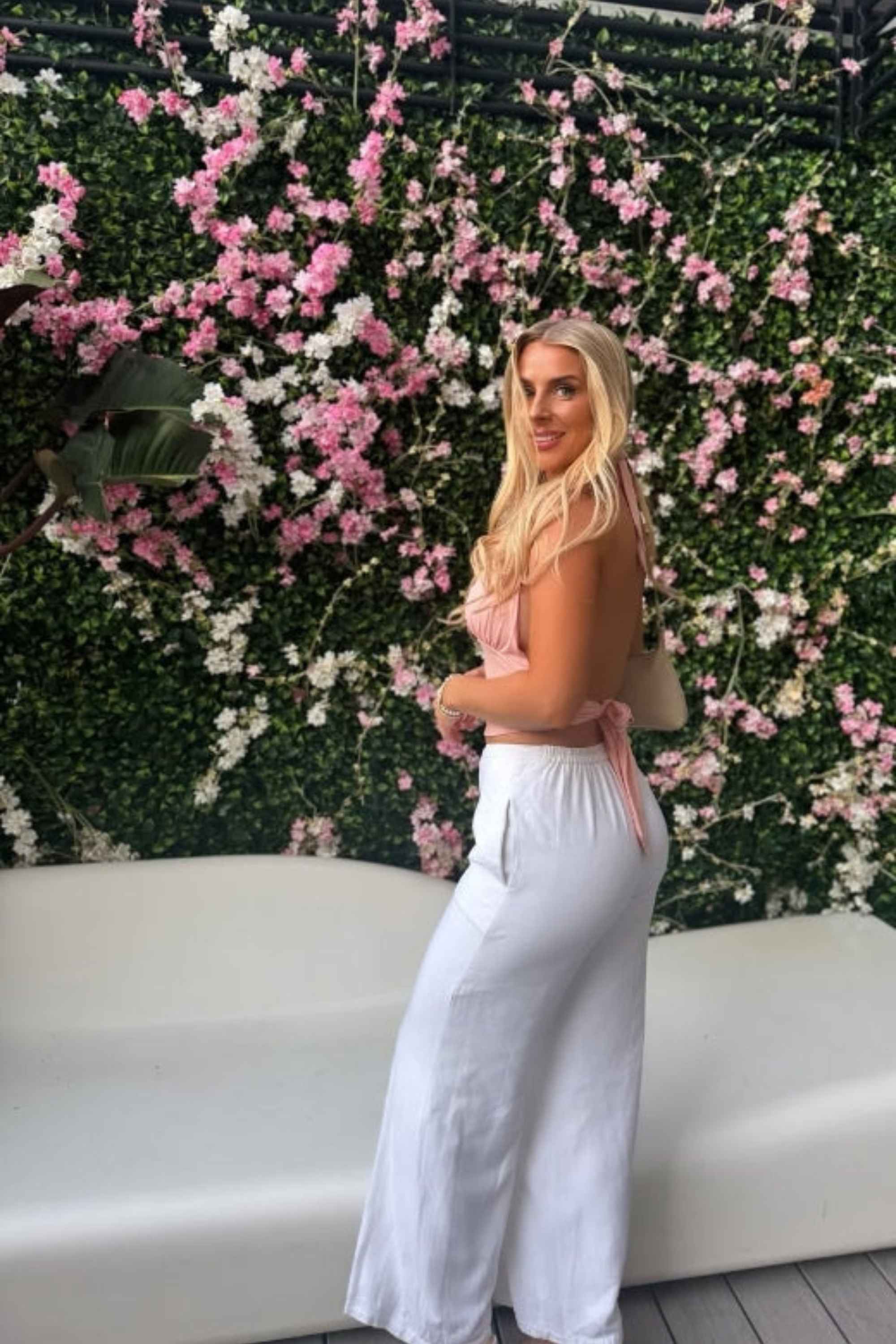 Woman wearing a figure flattering Aby Halter Top - Pink Peach Fuzz BODYCON COLLECTION Pty Ltd