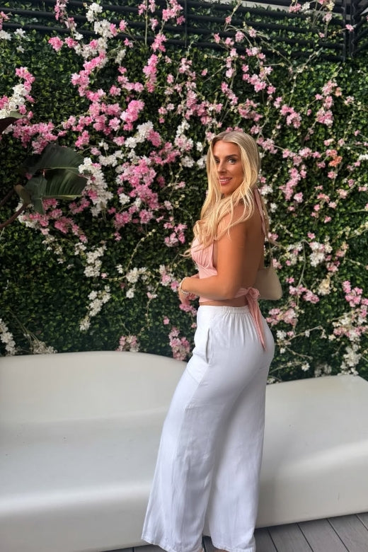 Woman wearing a figure flattering Aby Halter Top - Pink Peach Fuzz BODYCON COLLECTION Pty Ltd