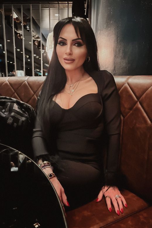 Woman wearing a figure flattering Erin Long Sleeve Bandage Mini Dress - Classic Black BODYCON COLLECTION