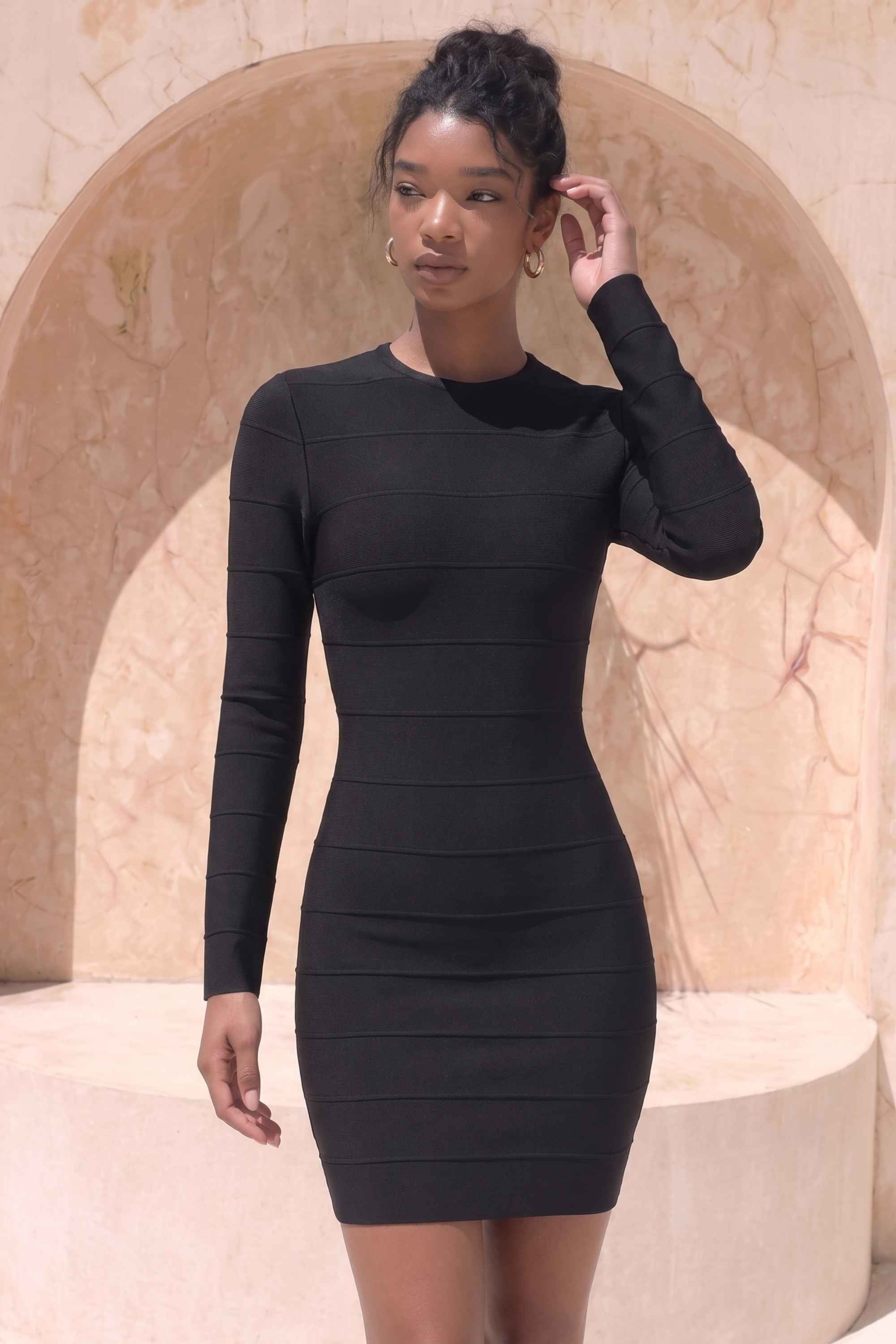 Woman wearing a figure flattering Pamela Long Sleeve Bandage Mini Dress - Classic Black BODYCON COLLECTION
