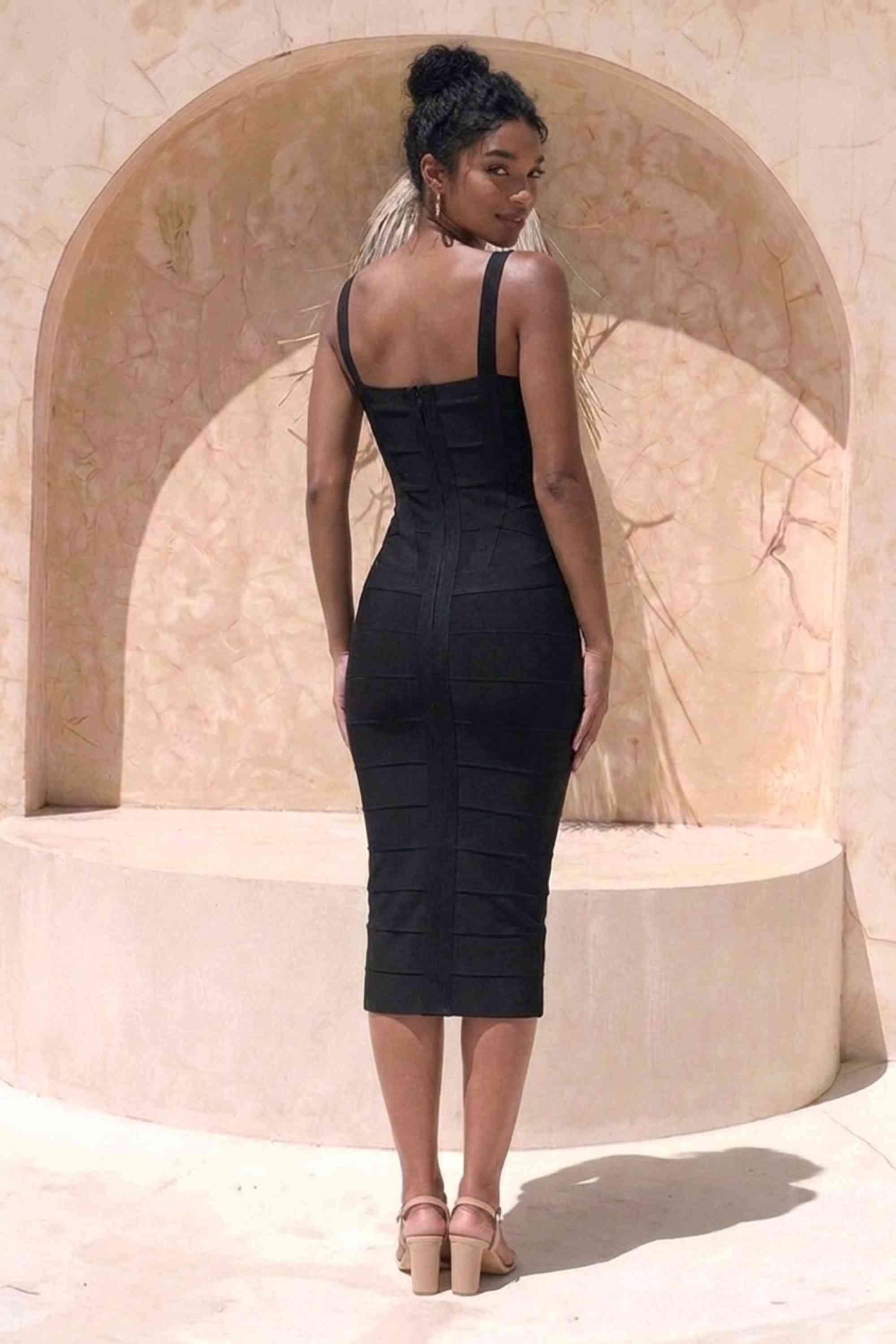Woman wearing a figure flattering  black party dress Heidi Bandage Midi Dress - Classic Black Bodycon Collection