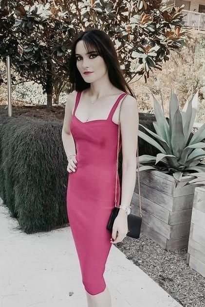 Woman wearing a figure flattering  Heidi Bandage Midi Dress - Magenta Pink Bodycon Collection
