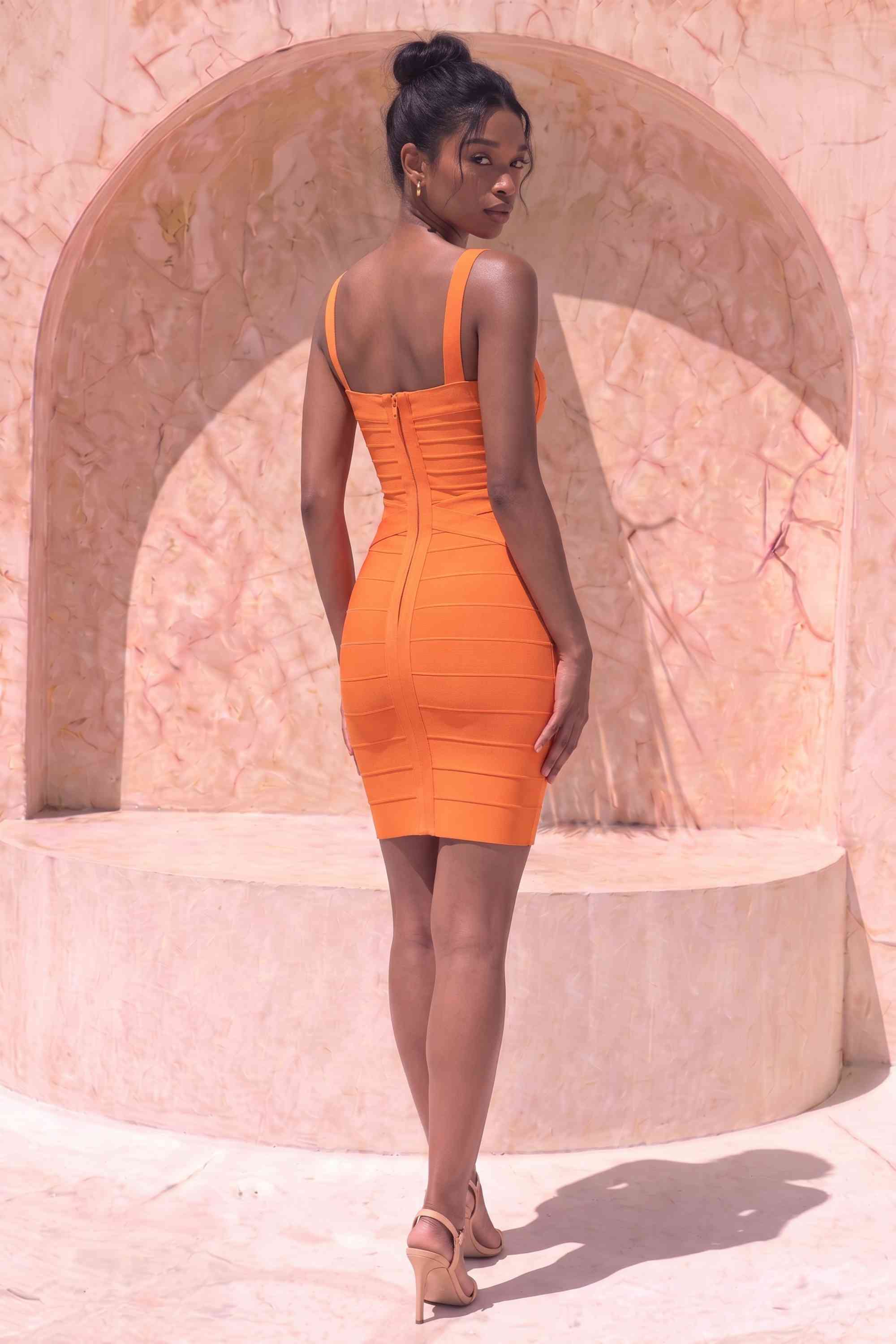 Woman wearing a figure flattering  Heidi Bandage Mini Dress - Apricot Orange Bodycon Collection