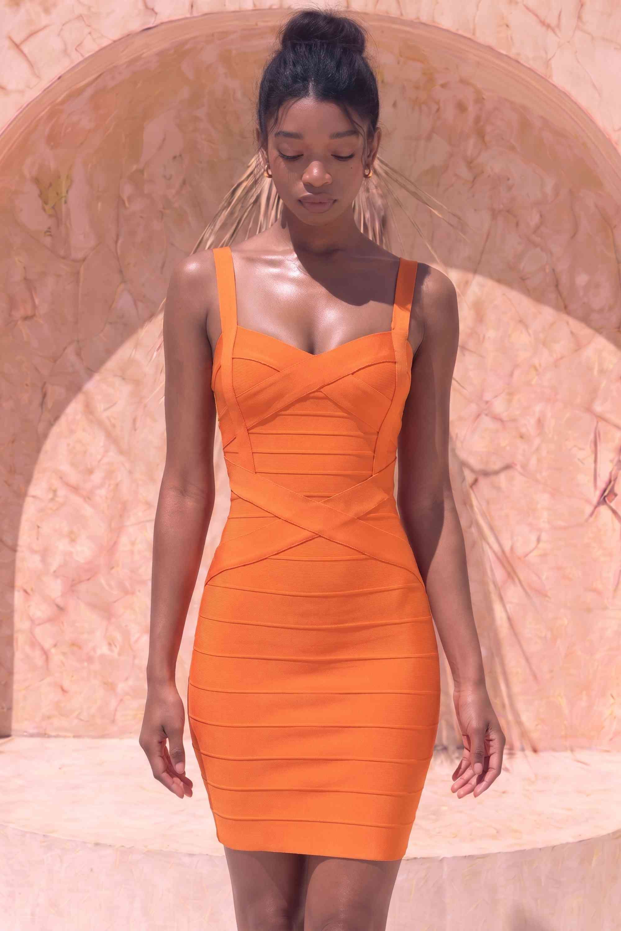 Woman wearing a figure flattering  Heidi Bandage Mini Dress - Apricot Orange Bodycon Collection