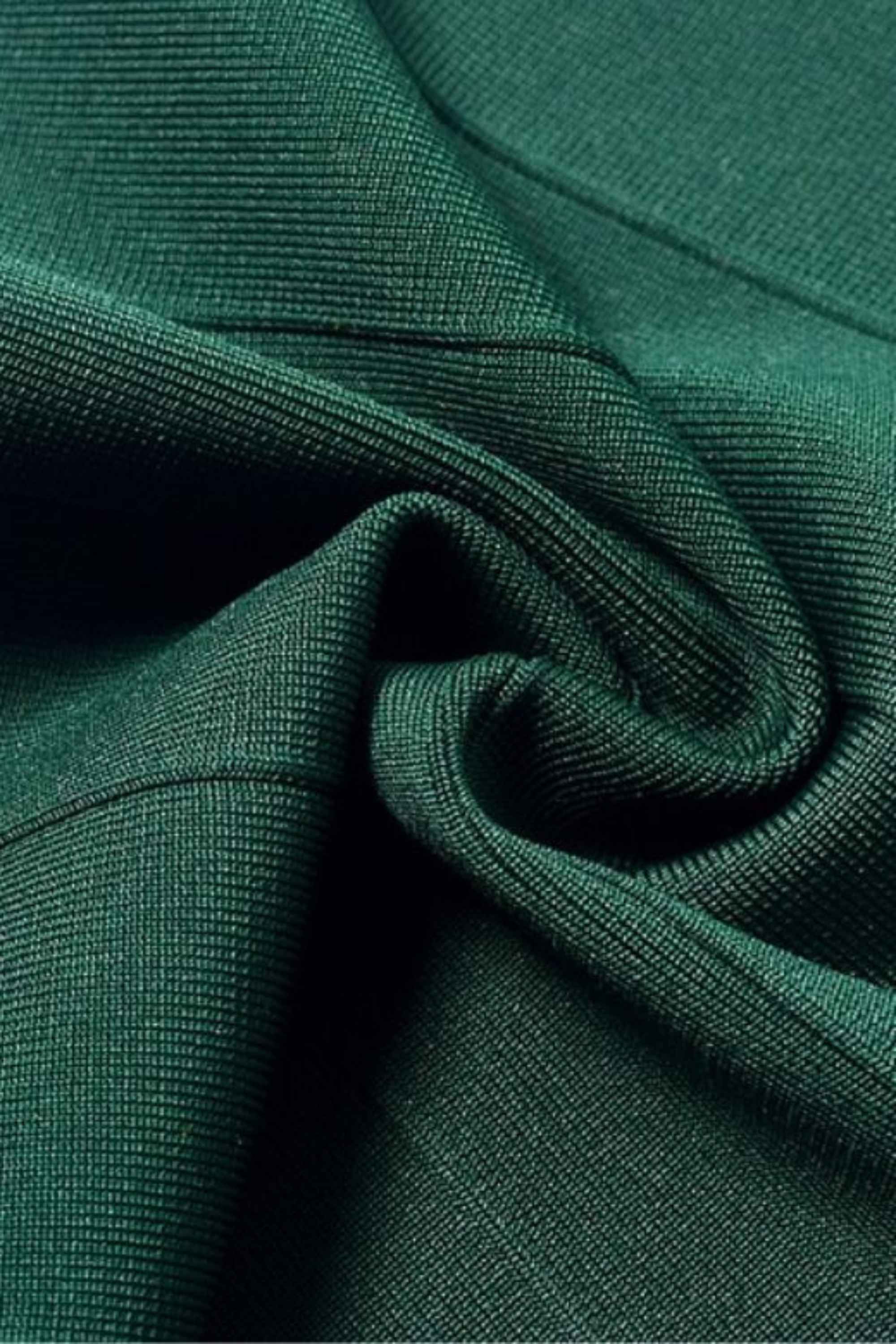 Woman wearing a figure flattering  Josie Bandage V Neck Mini Dress - Emerald Green BODYCON COLLECTION