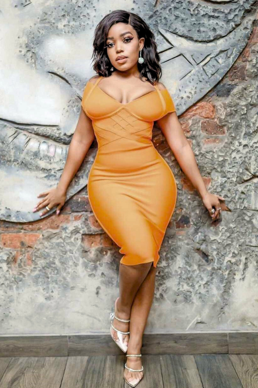 Woman wearing a figure flattering  Leo Bandage Midi Dress - Apricot Orange Bodycon Collection